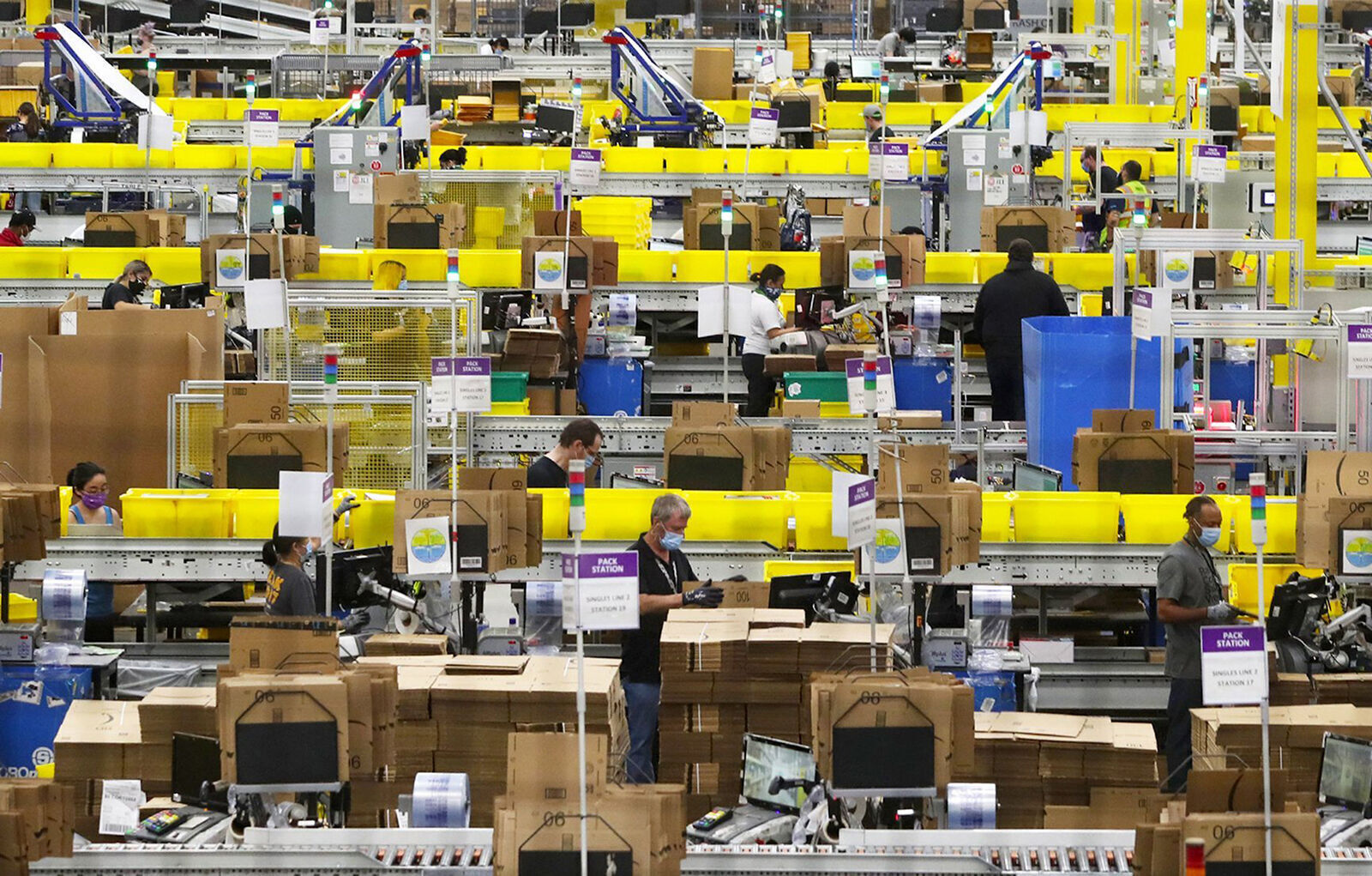 Employees at packing stations are seen at Amazon's Kent, Wash., fulfillment center on June 11, 2020.